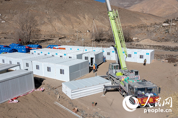 1月9日，在日喀則市定日縣長所鄉(xiāng)古榮村安置點(diǎn)，救援人員和施工人員合力抓緊搭建移動板房，確保受災(zāi)群眾溫暖過冬。人民網(wǎng)記者 翁奇羽攝