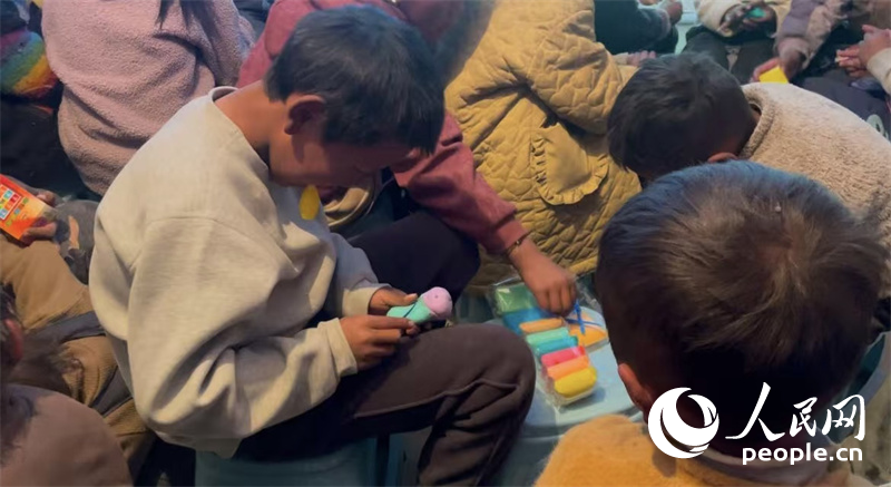 措果鄉(xiāng)塘仁村的孩子們正在用橡皮泥制作自己的情緒“小怪獸”。人民網記者 郝潔攝