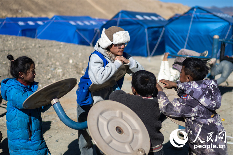 西藏星光社會工作服務中心社工久米旦增通過聊天談心，對孩子們進行災后心理疏導。人民網記者 翁奇羽攝
