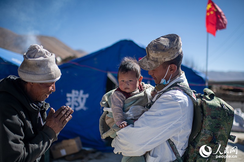 1月9日，在定日縣長所鄉(xiāng)古榮村安置點(diǎn)，受災(zāi)群眾感謝西藏軍區(qū)陸軍某部隊衛(wèi)生員的醫(yī)療救治。人民網(wǎng)記者 翁奇羽攝