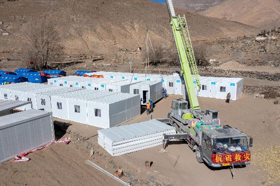 2025年1月9日，在定日縣長所鄉(xiāng)古榮村安置點，救援人員和施工人員合力抓緊搭建移動板房，確保受災(zāi)群眾溫暖過冬。人民網(wǎng)記者 翁奇羽攝
