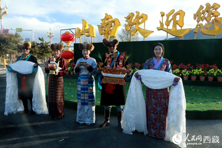 扎西曲登社區(qū)的居民在“山南歡迎您”標志前，手持潔白哈達和切瑪，列隊迎接來自區(qū)內外的游客，用最隆重的禮儀開啟一場沉浸式藏歷新年民俗體驗之旅。人民網(wǎng)記者 吳雨仁攝
