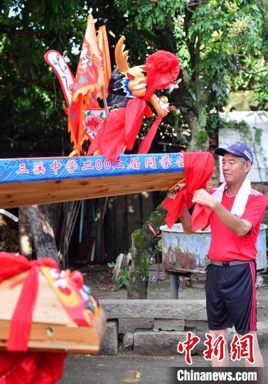 圖為5月29日，長樂江田鎮(zhèn)村民為即將入水的新龍舟系紅布?！埍?攝