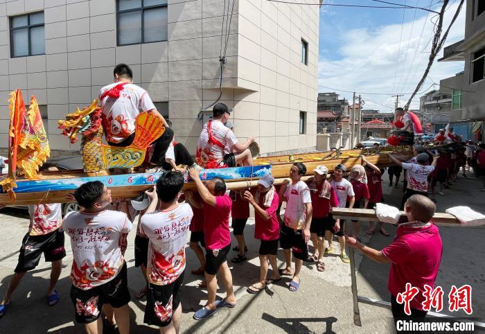 圖為5月29日，長樂江田鎮(zhèn)村民們肩扛著新龍舟舉行入水前游街儀式?！埍?攝