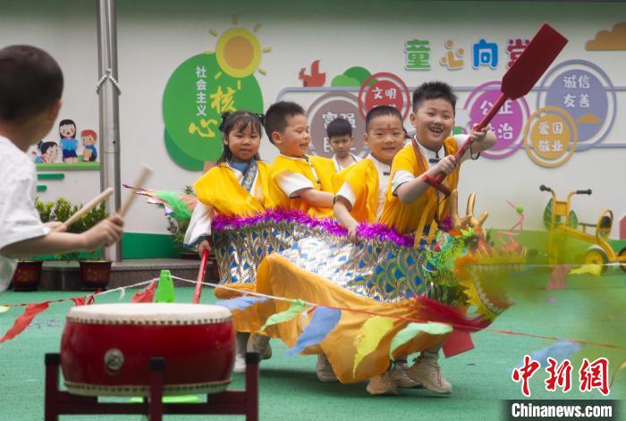 圖為龍舟賽游戲上，小伙伴們打鼓加油?！《^生 攝